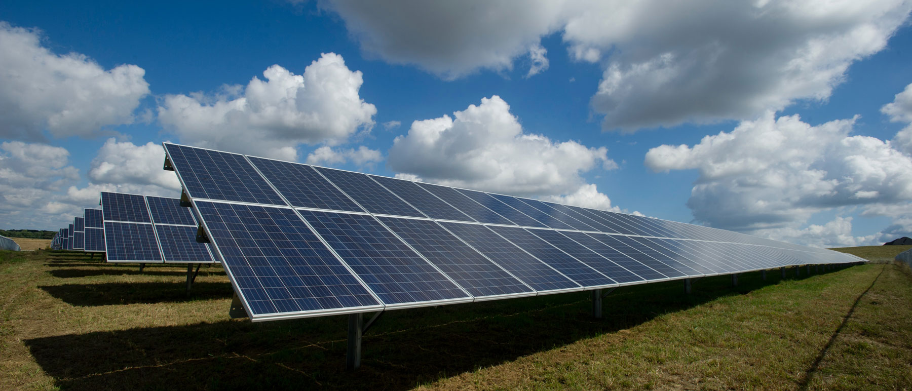 solar panels lined up in an open field on a sunny day